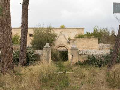 Siamo ora arrivati di fronte alla costruzione, introdotta da un �recinto� a forma di esedra in pietra tufacea, accanto a cui sorgono due alti pini marittimi